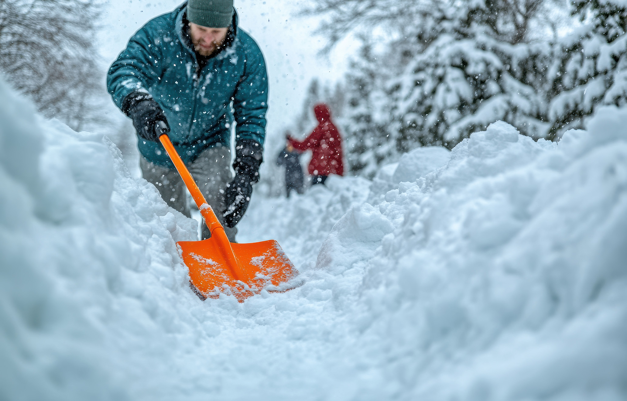 Person mit Schneeschaufel im Einsatz bei Schneefall