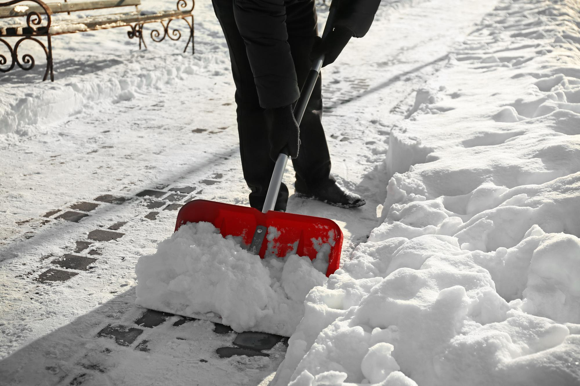 winterdienst-schaufel Rote Schneeschaufel im Einsatz bei Winterdienst