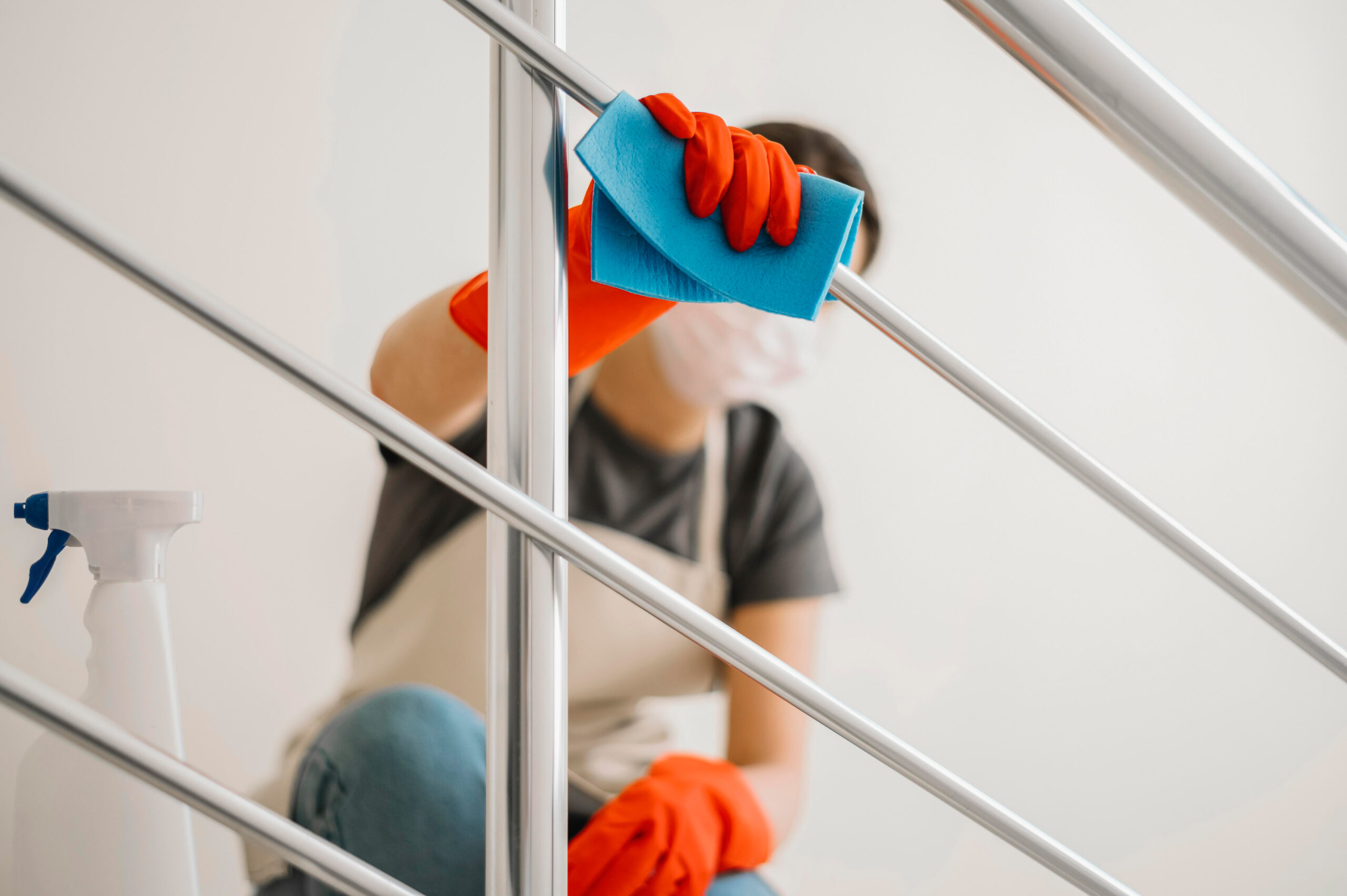 spuele-putzen-kueche Reinigungskraft schrubbt Küchenspüle mit Schwamm und Handschuhen